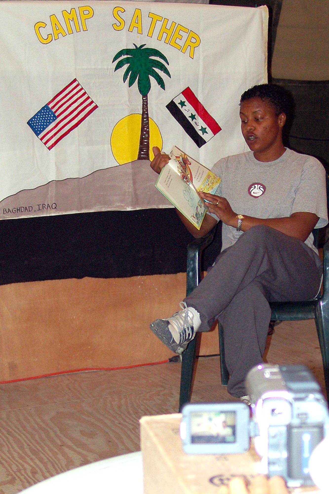 BAGHDAD, Iraq -- Staff Sgt. Tanya Evans reads "Chitty Chitty Bang Bang: The Magical Car" to her 3-year-old daughter, Tierra.  Sergeant Evans read the book on camera as part of a program created by 447th Air Expeditionary Group services flight Airmen at Camp Sather here.  She is assigned to the 447th Expeditionary Logistics Readiness Squadron and is deployed from the 56th LRS at Luke Air Force Base, Ariz.  (U.S. Air Force photo by Tech. Sgt. Michael O'Connor)
