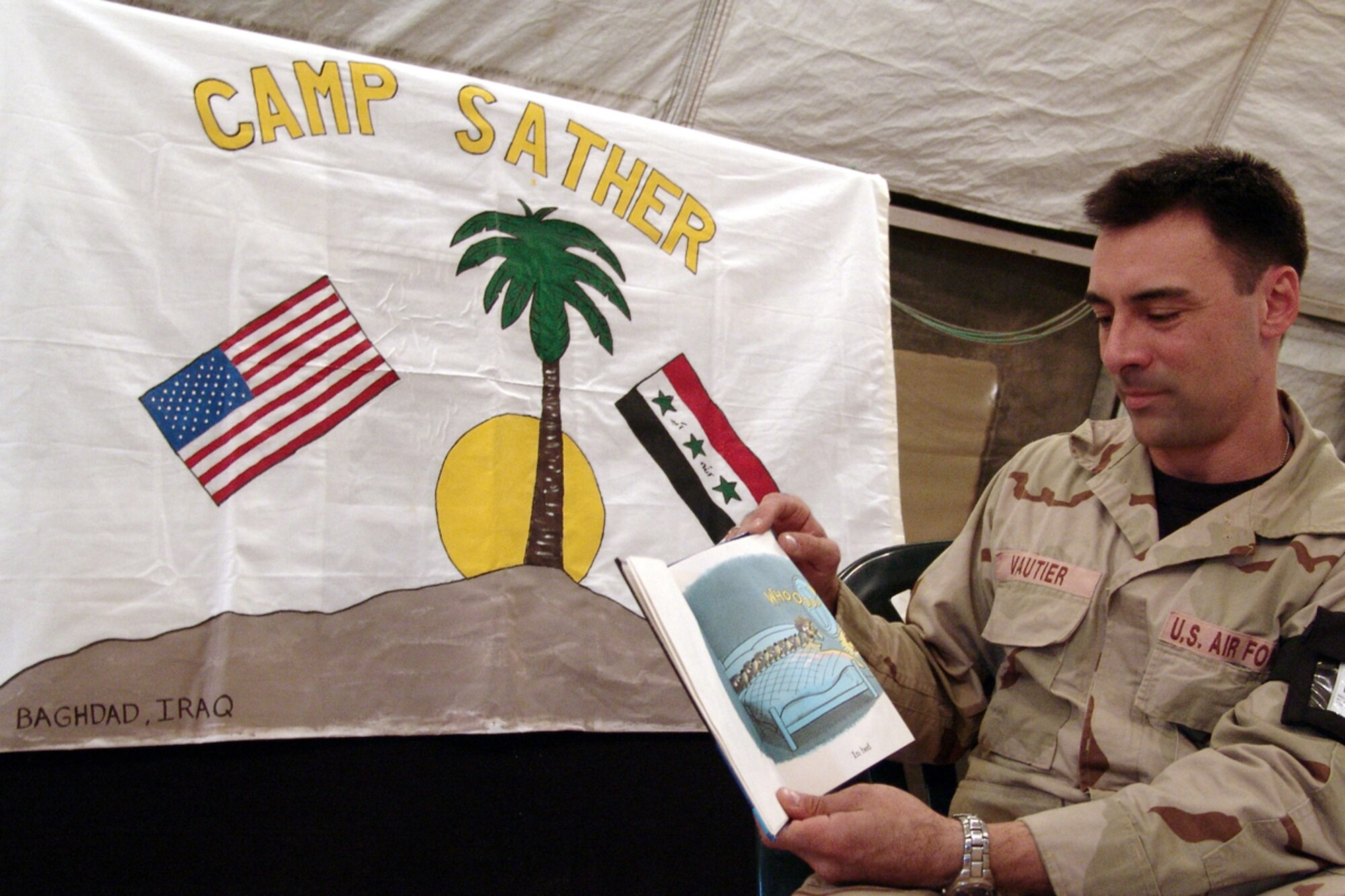 BAGHDAD, Iraq -- Staff Sgt. David Vautier reads "Bears in the Night" to his 2-year-old daughter, Lea Marie.  Sergeant Vautier read the book on camera as part of a program created by 447th Air Expeditionary Group services flight Airmen at Camp Sather here.  He is assigned to the 447th Expeditionary Logistics Readiness Squadron and is deployed from the 305th LRS at McGuire Air Force Base, N.J.  (U.S. Air Force photo by Tech. Sgt. Michael O'Connor)
