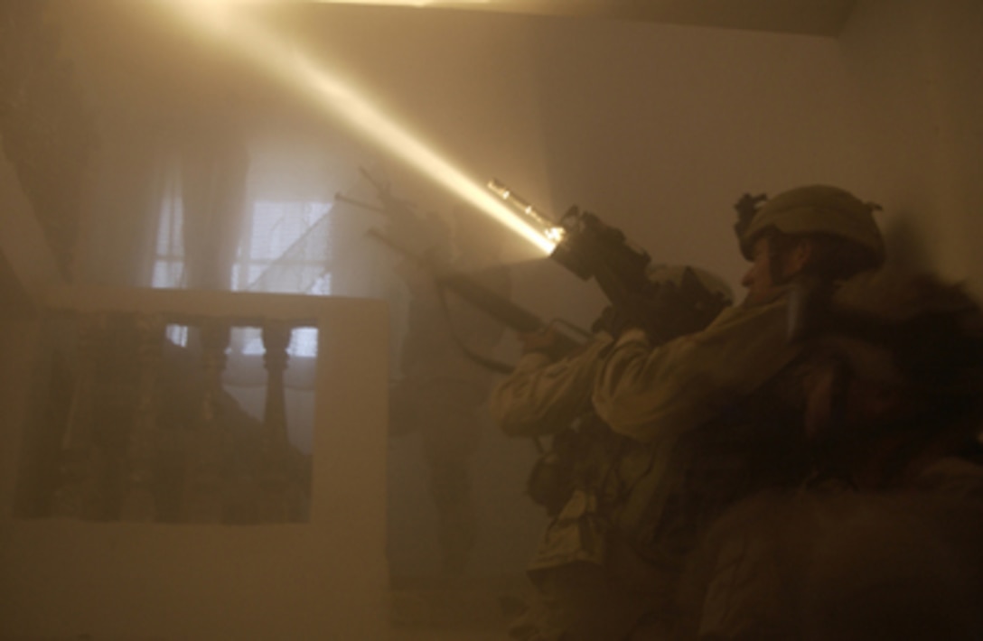 The beam of a flashlight fastened to a rifle cuts through the dust in the air as U.S. Army soldiers clear a house in Al Fallujah, Iraq, during Operation al Fajr (New Dawn) on Nov. 13, 2004. Al Fajr is an offensive operation to eradicate enemy forces within the city of Fallujah in support of continuing security and stabilization operations in the Al Anbar province of Iraq. The soldiers are assigned to the 82nd Engineer Battalion. 