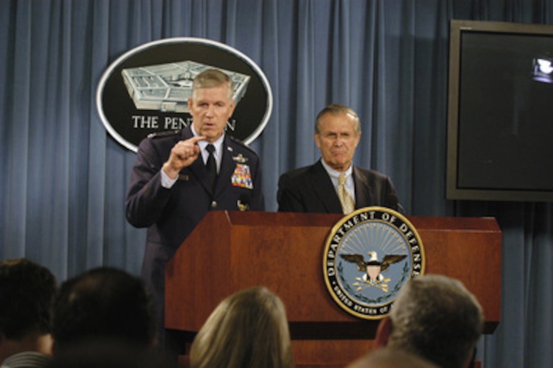 Secretary of Defense Donald H. Rumsfeld listens as Chairman of the Joint Chiefs of Staff Gen. Richard B. Myers, U.S. Air Force, responds to a reporter's question during a joint Pentagon press briefing on Nov. 23, 2004. 