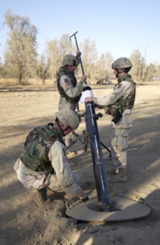 U.S. Army Pfc. Mathew Taylor (foreground), Spcs. Paul Sakala and Ryan Benoist clean their 120-millimeter mortar tube after firing high explosive rounds from Forward Operating Base Wilson in Iraq on Nov. 21, 2004. The mortar team is responsible for counter fire and terrain denial when anti-coalition forces fire mortar and rockets at the base. The soldiers are assigned to Charlie Troop, 1st Battalion, 4th Cavalry Regiment, 1st Infantry Division. 