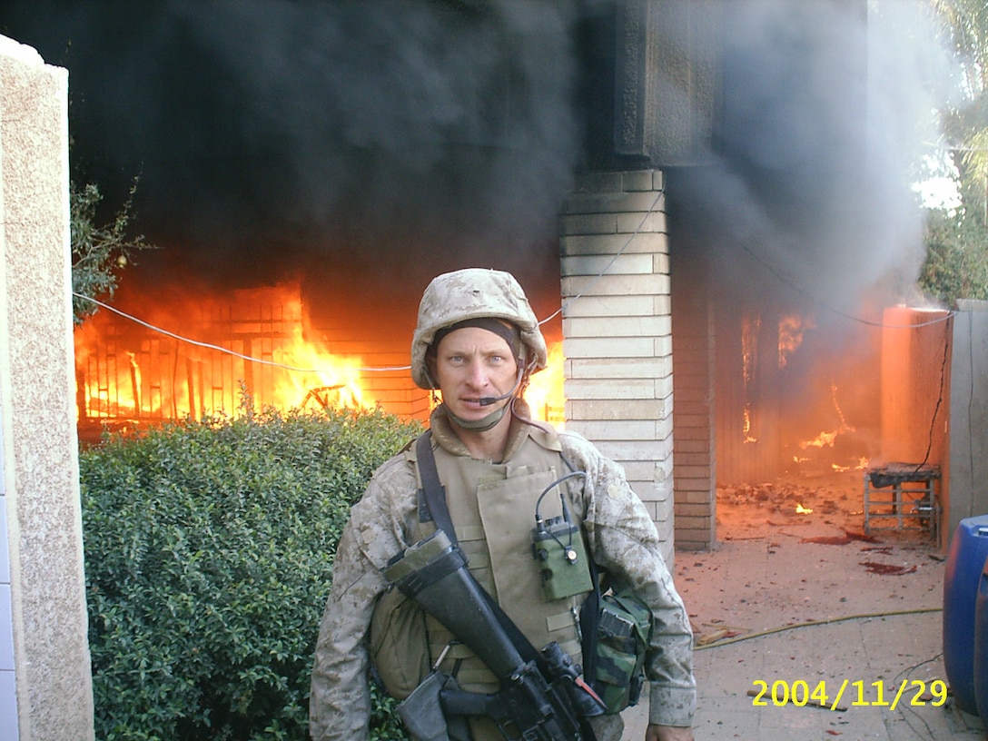 Staff Sgt. Ralph Scott, a native of Tallahassee, Fla., stands in front of a burning building in Fallujah, Iraq, during Operation Iraq Freedom II. Scott was recently awarded the Bronze Star with combat V for his heroism in Iraq while serving in an officers billet as the platoon commander for 1st Platoon, Charlie Company, 1st Battalion, 3rd Marine Regiment.