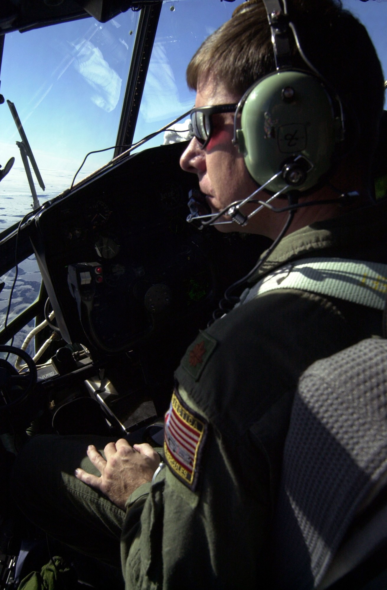 OVER ANTARCTICA -- Maj. Mark Doll, a pilot with the New York Air National Guard's 109th Airlift Wing, looks out the window of an LC-130 Hercules over the area of Antarctica where Rear Adm. Richard E. Byrd established the Little America campsite 75 years ago.  The edge of the Ross Ice Shelf and the sea ice in the area where Admiral Byrd established Little America broke off and floated away years ago.   Major Doll and his crew took the long way to the pole to retrace the route of the first South Pole flight by Admiral Byrd.  (Courtesy photo)