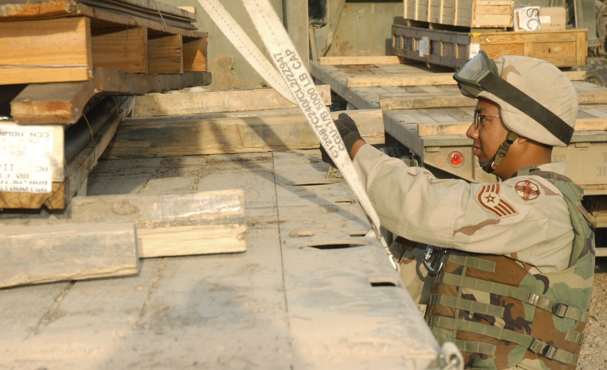 BALAD AIR BASE, Iraq -- Staff Sgt. Radley Jacinto straps down cargo on a tractor-trailer at the cargo yard here.  Sergeant Jacinto is a vehicle operator assigned to the Arrival/Departure Air Cargo Group.  The group recently set a one-day record by moving more than 1.3 million pounds of cargo.  The Airmen are part of Detachment 2632 of the 732nd Expeditionary Logistics Readiness Squadron.  (U.S. Air Force photo by Staff Sgt. Marc Barnes)