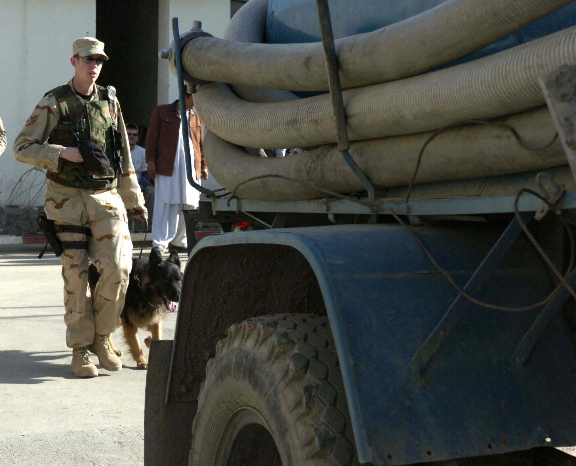 KABUL COMPOUND, Afghanistan -- Staff Sgt. David Yepsen and his military working dog, Dax, prepare to search a vehicle that has just entered the compound.  The two are the only Air Force canine team in Afghanistan.  They are deployed supporting Operation Enduring Freedom from the 43rd Security Forces Squadron at Pope Air Force Base, N.C.  (U.S. Air Force photo by Senior Airman Catharine Schmidt)