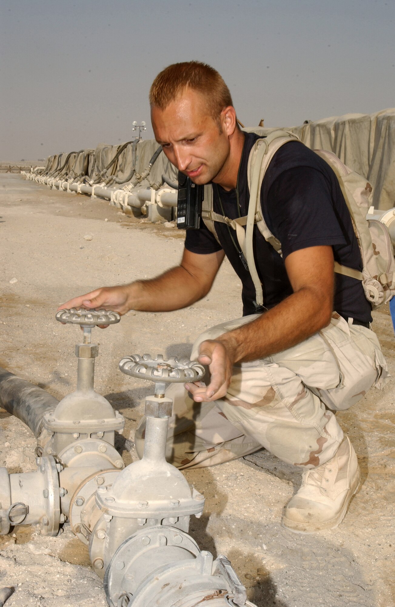 SOUTHWEST ASIA -- Staff Sgt. Chris Bass operates valves to transfer fuel between storage bladders at a forward-deployed location.  He is a fuel systems operator assigned to the 380th Expeditionary Logistics Readiness Squadron's fuels flight.  (U.S. Air Force photo by Tech. Sgt. Gino Mattorano) 