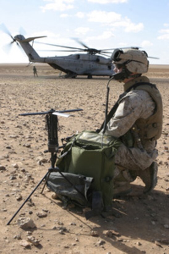 U.S. Marine Lance Cpl. Robert Dacker establishes communication as a CH-53E Super Stallion helicopter waits near the Iraqi- Syrian border on Nov. 18, 2004. The 31st Marine Expeditionary Unit Marines and sailors are inspecting the forts along the Iraqi-Syrian border to assess the condition of the forts under construction. Dacker is assigned to 1st Battalion, 23rd Marine Regiment. 