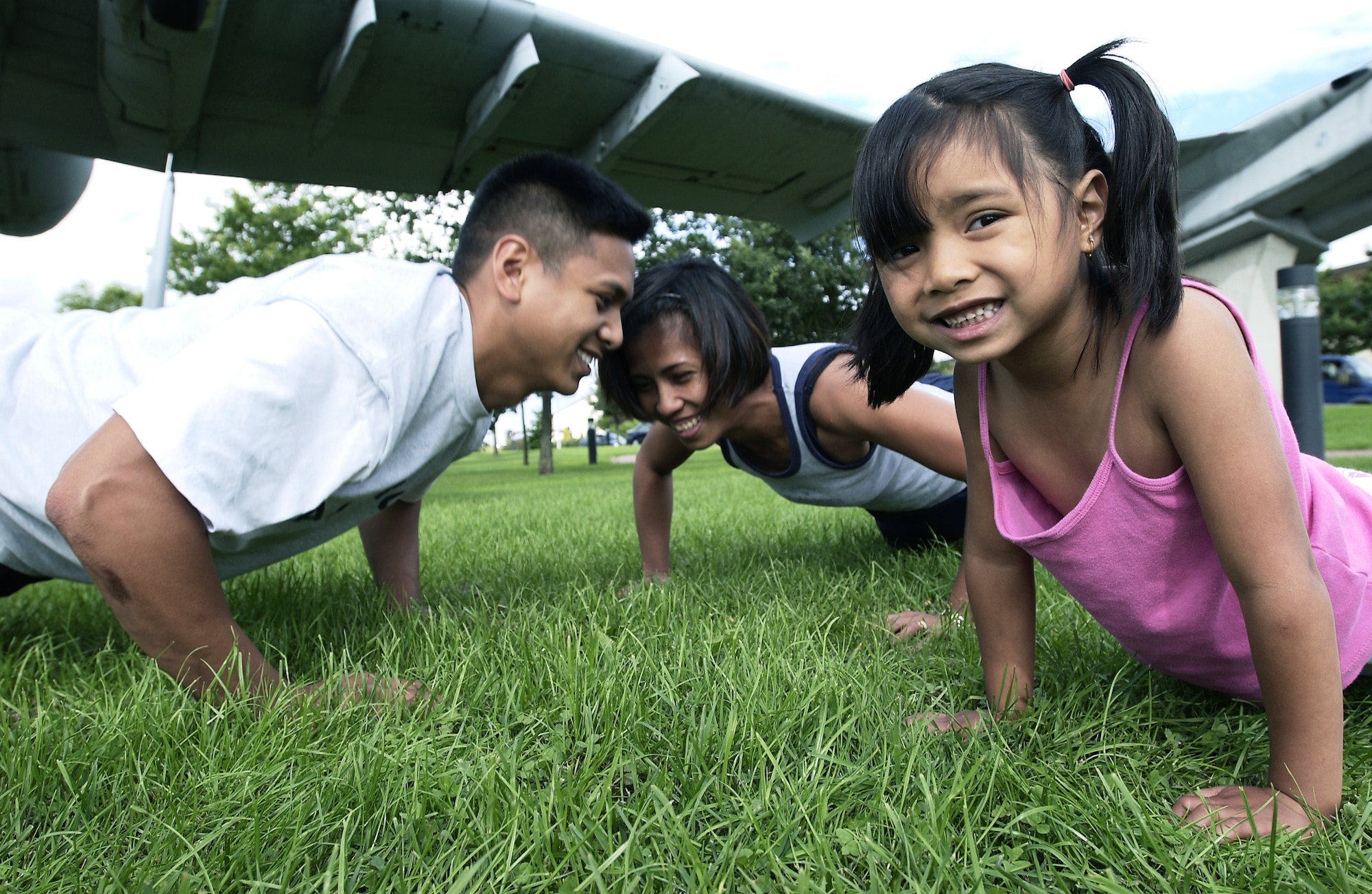 SPANGDAHLEM AIR BASE, Germany -- Staff Sgts. Rodolfo (left) and Mary Anne Reyes have made working out a family affair.  Five-year-old Reanna shows her warrior spirit by doing push-ups with her mom during daily workouts at home.  (U.S. Air Force photo by Master Sgt. Keith Reed)