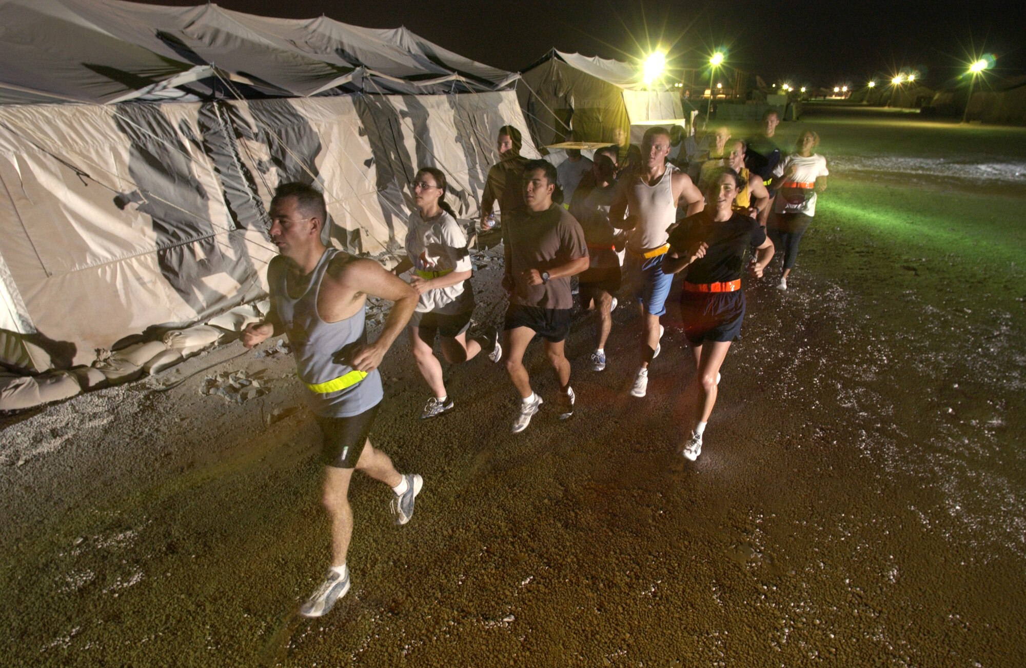 AL UDEID AIR BASE, Qatar -- Airmen from the 379th Air Expeditionary Wing here participate in an evening "fun run" to keep fit and escape the daytime heat.  Airmen worldwide are on a similar track in preparing for the new Air Force fitness test that replaces cycle ergometry with running, push-ups and sit-ups.  (U.S. Air Force photo by Master Sgt. Lance Cheung) 