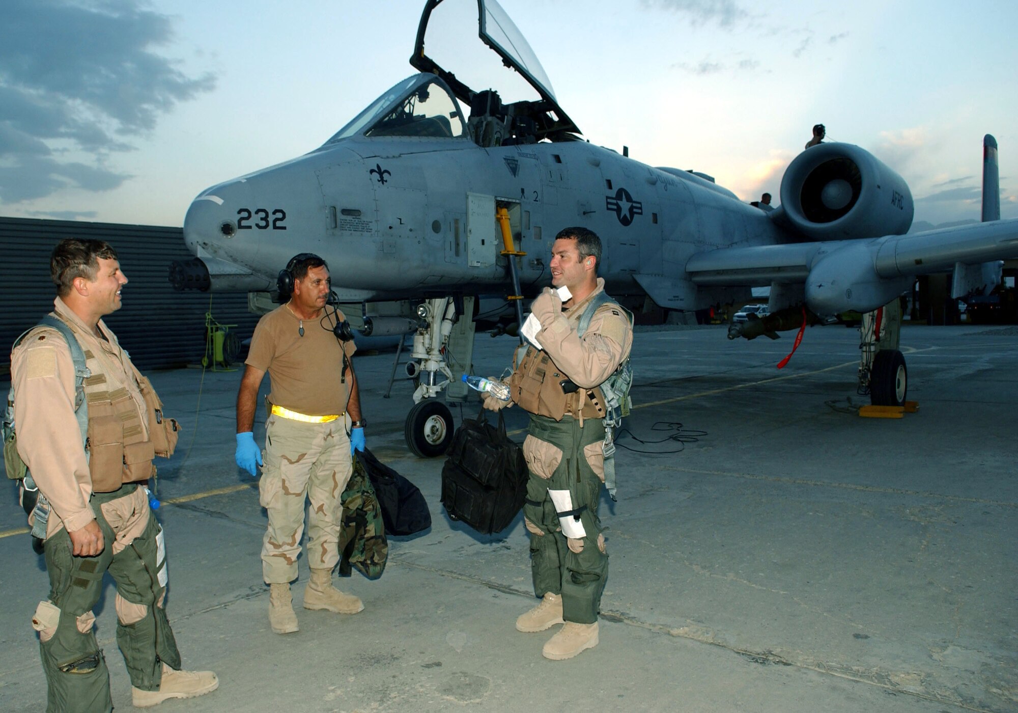 BAGRAM AIR BASE, Afghanistan -- "S-Flight 3" flight lead Capt. Brian (right) talks about a mission's events with his wingman, Maj. Charlie (far left) and Tech. Sgt. Randolph Dandry.  The 81st Expeditionary Fighter Squadron team provided aerial cover for a U.S. military convoy under attack recently.  Sergeant Dandry is a crew chief with the 81st Expeditionary Aircraft Maintenance Squadron.  They are all deployed from Naval Air Station Joint Reserve Base New Orleans.  (The aircrew's full names are omitted for security reasons.  U.S. Air Force photo by Staff Sgt. Jennifer Lindsey)