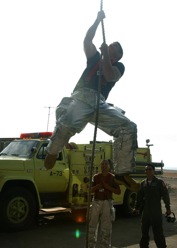 IQUIQUE, Chile -- Senior Airman Jeremiah Hanna-Cruz lowers himself during rope training as Airman 1st Class Larry Trejos (left) and Chilean air force Airman Marco Godoy watch.  The Airmen are participating in Salitre 2004, a multinational air combat training exercise among Chile, Argentina, Brazil and the United States.  More than 100 U.S. active-duty and Air National Guard Airmen are participating in the two-week exercise that runs through Oct. 8 at Los Condores Air Base here.  Airmen Hanna-Cruz and Trejos are assigned to the 28th Civil Engineer Squadron at Ellsworth Air Force Base, S.D.  (U.S. Air Force photo by Staff Sgt. Matthew Lohr)