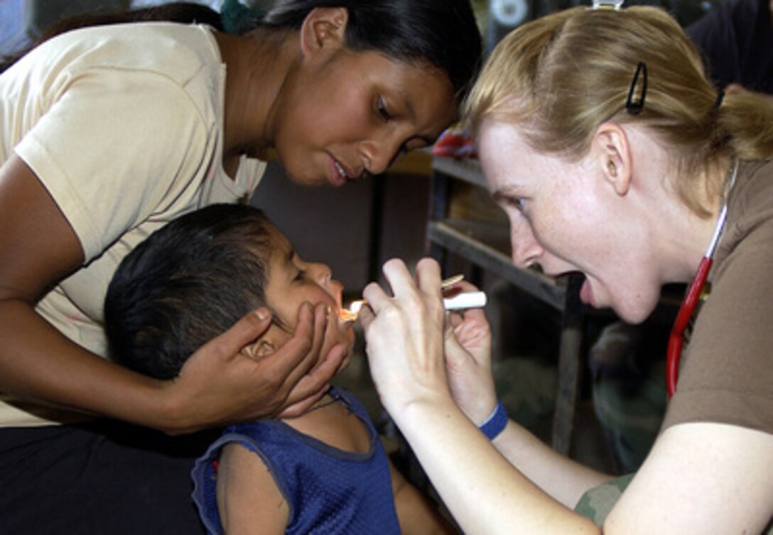 Air Force Capt. Carrie Schmid examines the mouth of a Honduran child during medical readiness training in the village of San Antonio near the city of Comayagua, Honduras, on Sept. 22, 2004. Medical personnel from Soto Cano Air Base in Honduras organized this medical readiness training for doctors from Wilford Hall Medical Center and the Uniformed Services University of Health Sciences in Bethesda, Md. The doctors treated hundreds of children and expectant mothers over a three-day period. 
