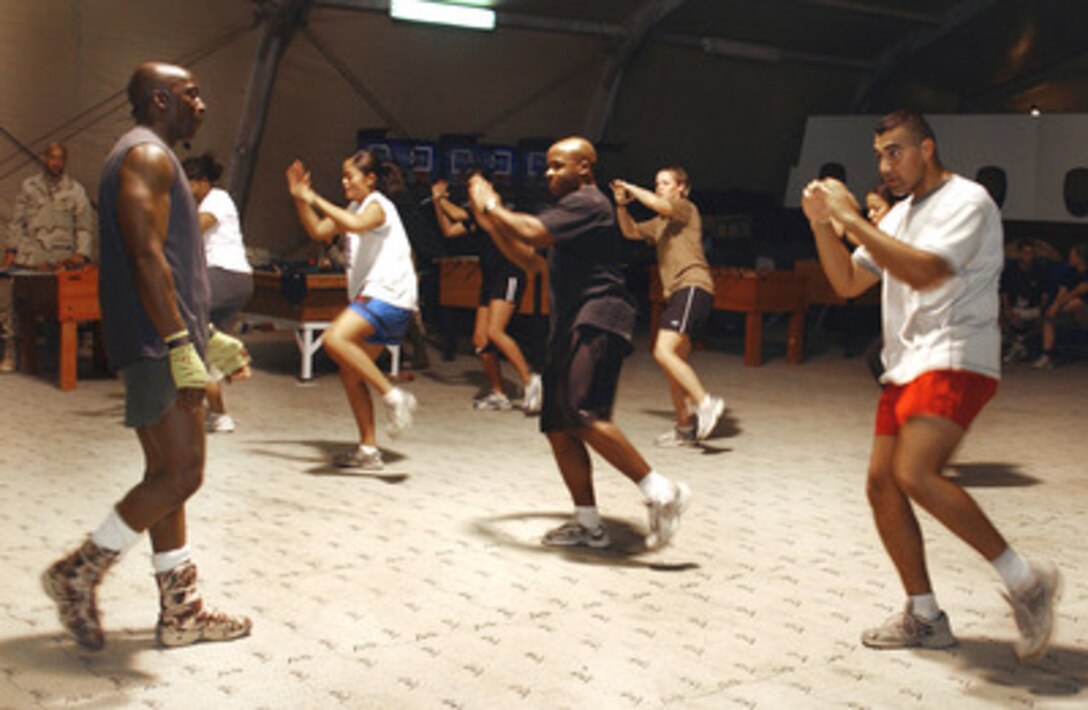 The creator of Tae Bo, Billy Blanks, leads an aerobic training session for military personnel stationed at Kirkuk Air Base, Iraq, on Sept. 28, 2004. Blanks toured several bases throughout Iraq signing autographs and performing aerobic training sessions for troops. 