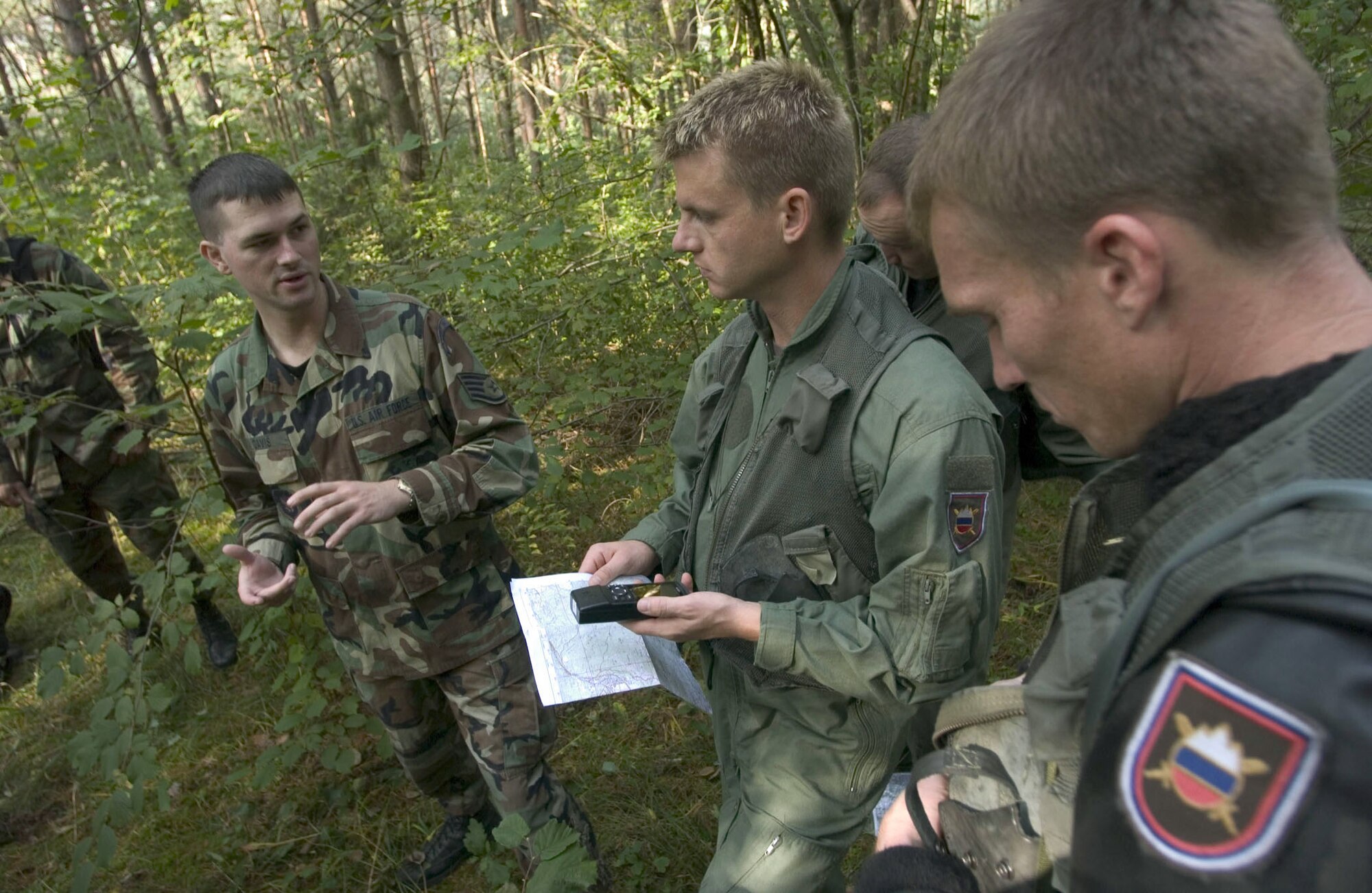 POCEK, Slovenia -- Staff Sgt. James Davis (left) shows Slovenian Lt. Roskar Zelko (center) and Slovenian Maj. Ales Stimec how to use a Global Positioning System receiver during combat search-and-rescue training here Oct. 5.  Sergeant Davis is a survival escape, resistance and evasion instructor at Aviano Air Base, Italy.  American and Slovenian Airmen exchanged information concerning escape and evasion procedures during Adriatic Rescue '04, a U.S.-Slovenian combat search-and-rescue exercise.  (U.S. Air Force photo by Master Sgt. John E. Lasky)