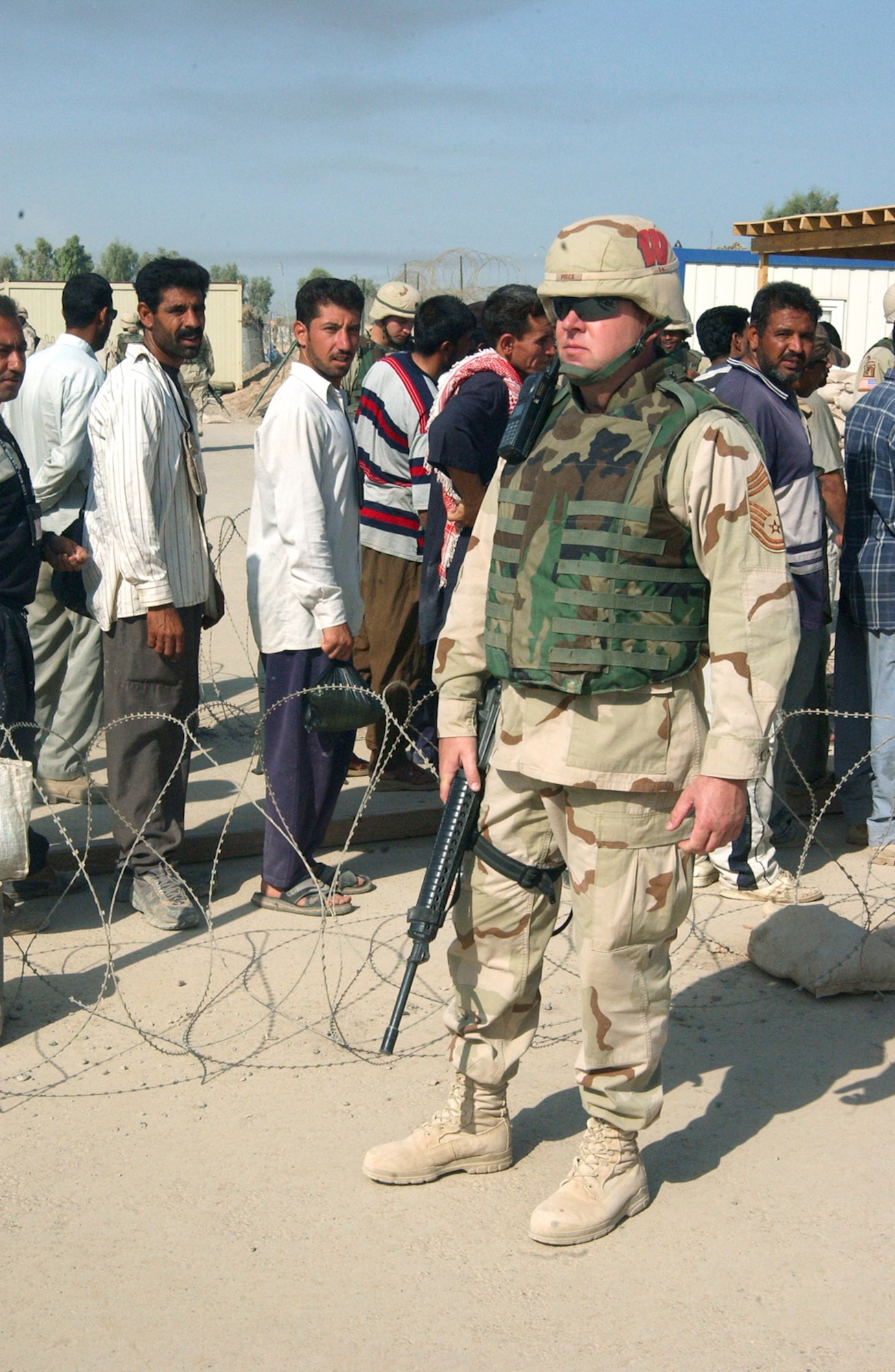 BALAD AIR BASE, Iraq -- Chief Master Sgt. Erik Price watches as workers enter the gate Oct. 4.  He is the security escort program manager with the 332nd Expeditionary Civil Engineer Squadron here and is deployed from the Wisconsin Air National Guard.  (U.S. Air Force photo by Airman 1st Class Joshua Jasper)
