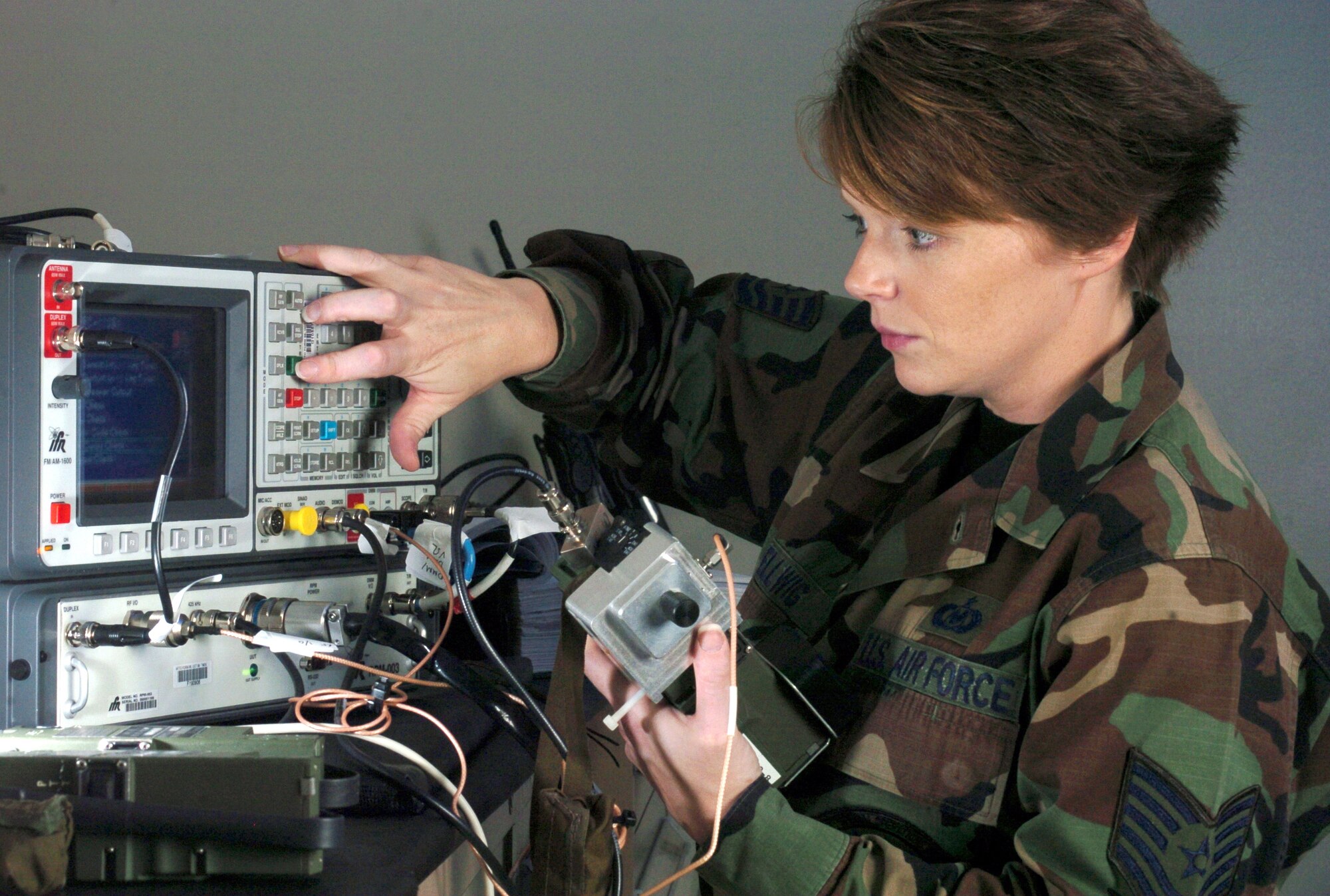 KADENA AIR BASE, Japan -- Tech. Sgt. Jennifer Hellwig inspects a survival radio here.  She is a life-support technician with the 17th Special Operations Squadron.  (U.S. Air Force photo by Master Sgt. Val Gempis)
