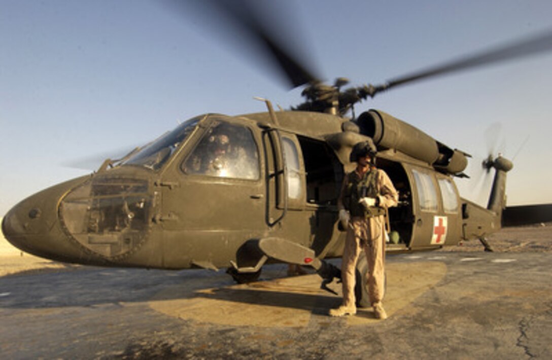 U.S. Army Sgt. John Foxworthy stands beside a UH-60 Blackhawk helicopter as he waits to meet a patient at a landing zone in Camp Victory, Iraq, on Aug. 23, 2004. Foxworthy is a medical technician from the 45th Medical group. 