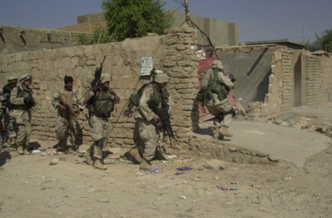 U.S. Army and Iraqi National Guard soldiers prepare to enter and search a house during Operation Baton Rouge, a joint combat operation in Samarra, Iraq, on Oct. 1, 2004. The U.S. Army soldiers are with the 1st Battalion, 77th Armor Regiment, 1st Infantry Division. 