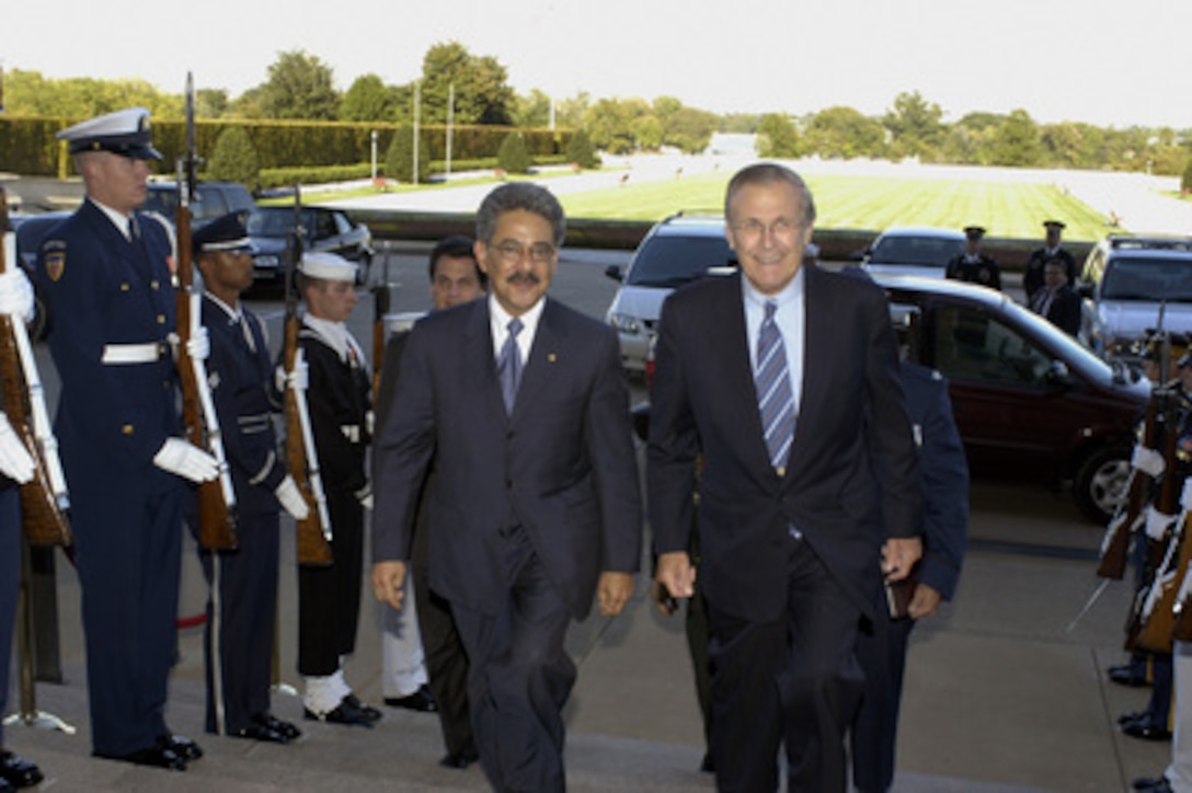 Honduran Minister of Defense Federico Breve (left) is escorted through an honor cordon and into the Pentagon by Secretary of Defense Donald H. Rumsfeld on Oct. 6, 2004. Breve will meet with Rumsfeld to discuss defense issues of mutual interest. 