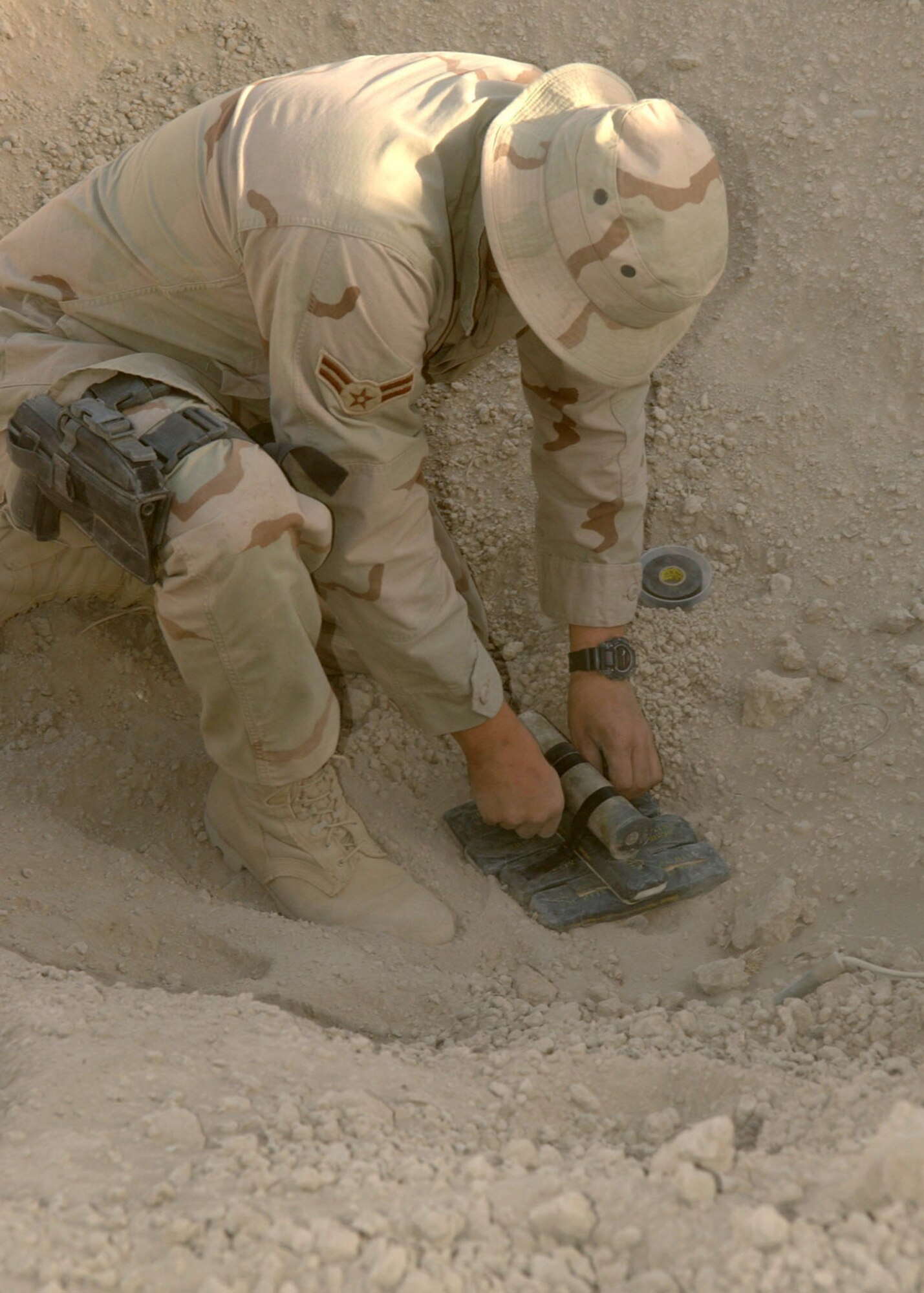 BAGRAM AIR BASE, Afghanistan -- Airman 1st Class Christopher, whose last name is omitted for security reasons, places C-4 on unexploded ordnance.  He is an explosive ordnance disposal technician with the 455th Civil Engineer Flight here.  Airman Christopher is deployed from Elmendorf Air Force Base, Alaska, supporting Operation Enduring Freedom.  (U.S. Air Force photo by Staff Sgt. Jennifer Lindsey)