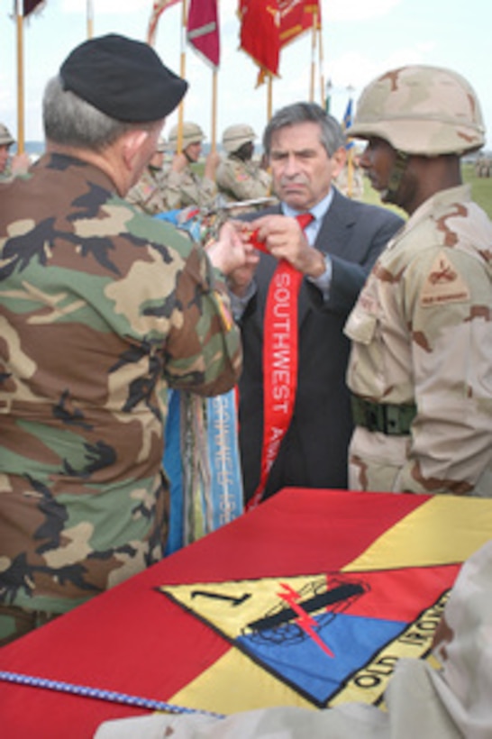 Deputy Secretary of Defense Paul Wolfowitz and Army Chief of Staff Gen. Peter J. Schoomaker attach new campaign streamers to the colors of the 1st Armored Division during homecoming ceremonies marking the return of the division from its combat deployment in Iraq to its headquarters in Weisbaden, Germany on Oct 7, 2004. The streamers commemorate the division's participation in recent combat operations in Iraq. 
