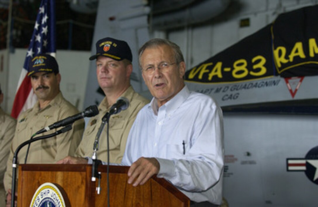 Secretary of Defense Donald H. Rumsfeld addresses the crew during a reenlistment ceremony aboard the USS John F. Kennedy (CV 67) on Oct 9, 2004. Rumsfeld is onboard the aircraft carrier to meet with crewmembers and host coalition ministers of defense. 