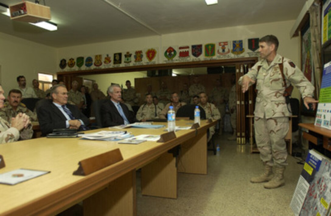 Secretary of Defense Donald H. Rumsfeld (left) receives a briefing from the Commander of the 1st Infantry Division Maj. Gen. John F. Batiste, U.S. Army, in Kirkuk, Iraq, on Oct. 10, 2004. Rumsfeld is in Iraq to meet and show support for the coalition troops and meet with Iraqi officials. 