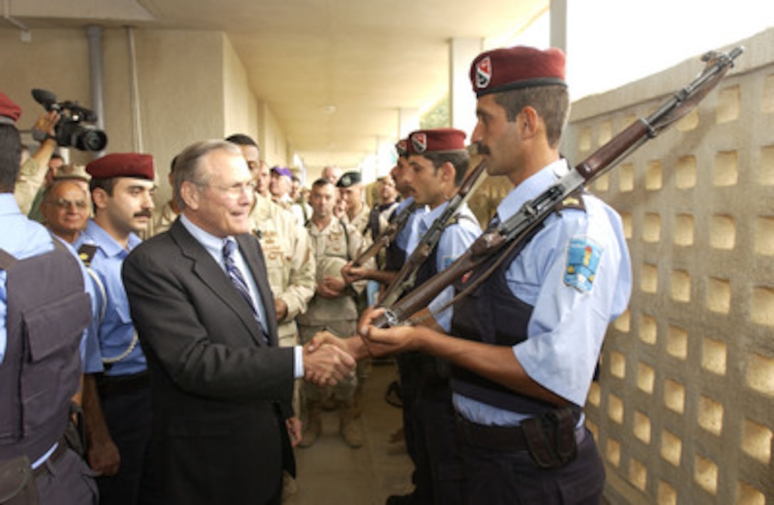 Secretary of Defense Donald H. Rumsfeld (center) shakes hands with Iraqi National Guard members near Kirkuk, Iraq, on Oct. 10, 2004. Rumsfeld is in Iraq to show support for the coalition troops and meet with Iraqi officials. 