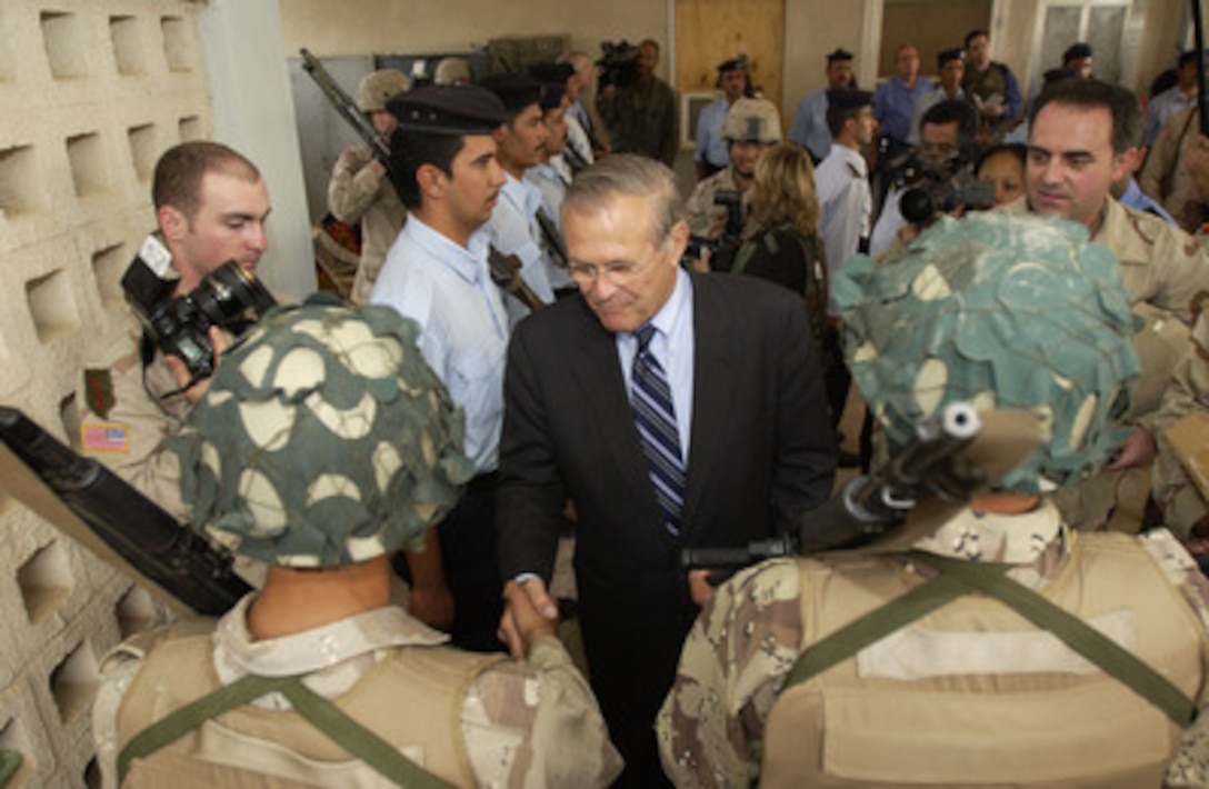 Secretary of Defense Donald H. Rumsfeld (center) shakes hands with Iraqi National Guard members near Kirkuk, Iraq, on Oct. 10, 2004. Rumsfeld is in Iraq to show support for the coalition troops and meet with Iraqi officials. 