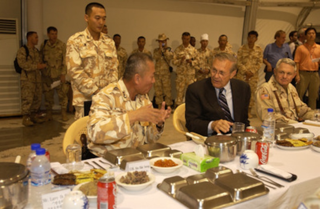 Secretary of Defense Donald H. Rumsfeld (2nd from right) has dinner with the Commander of the Republic of Korea Division Maj. Gen. Hwang Ui-don in Irbil, Iraq, on Oct 10, 2004. Rumsfeld is in Iraq to show support for the coalition troops and meet with Iraqi officials. 