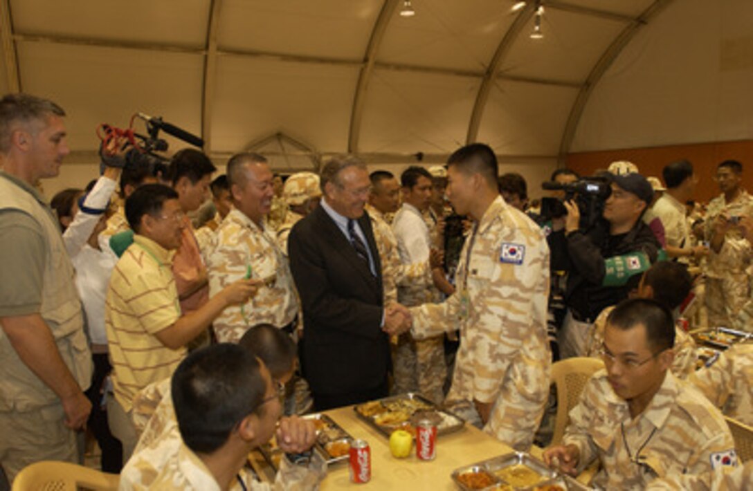 Secretary of Defense Donald H. Rumsfeld (center) meets with Korean soldiers in Irbil, Iraq, on Oct 10, 2004. Rumsfeld is in Iraq to show support for the coalition troops and meet with Iraqi officials. 