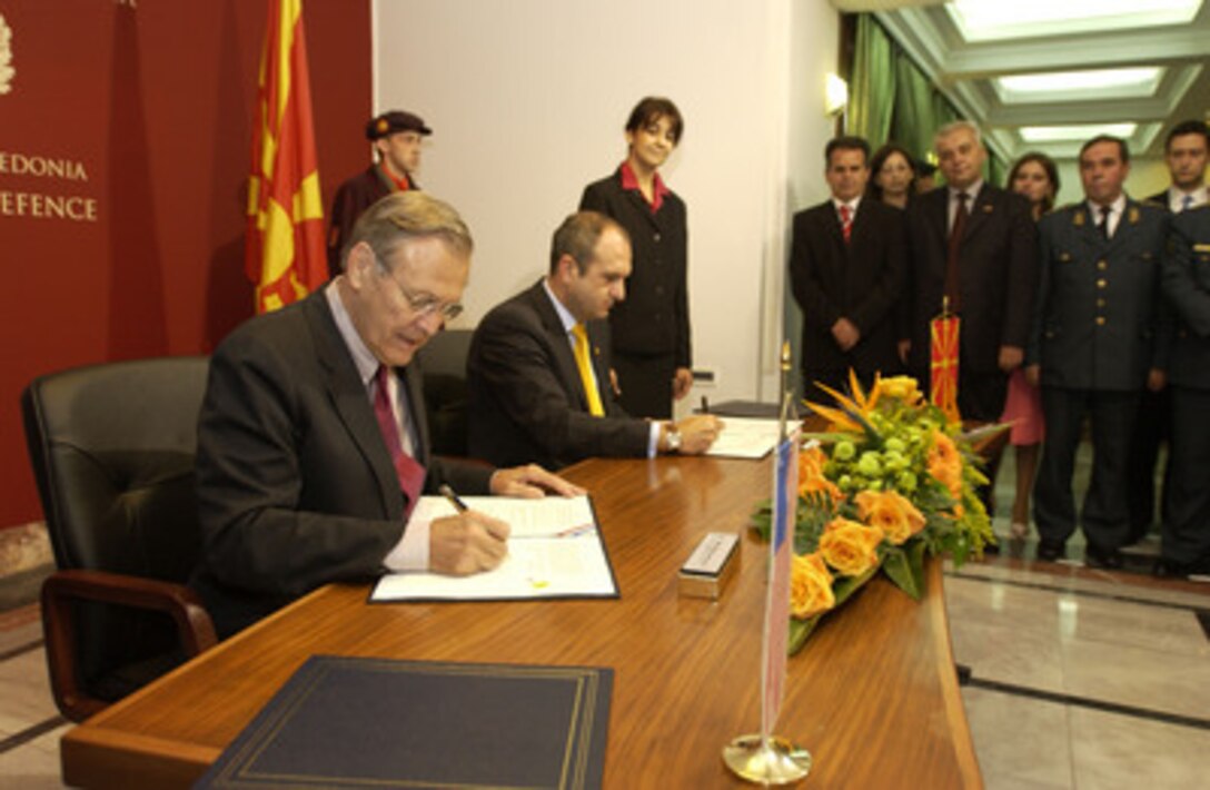 Secretary of Defense Donald H. Rumsfeld (left) and Macedonian Minister of Defense Vlado Buckovsk sign a Weapons of Mass Destruction agreement in Skopje, Macedonia, on Oct 11, 2004. Rumsfeld is in Skopje to attend a bi-lateral meeting with Macedonia officials. 