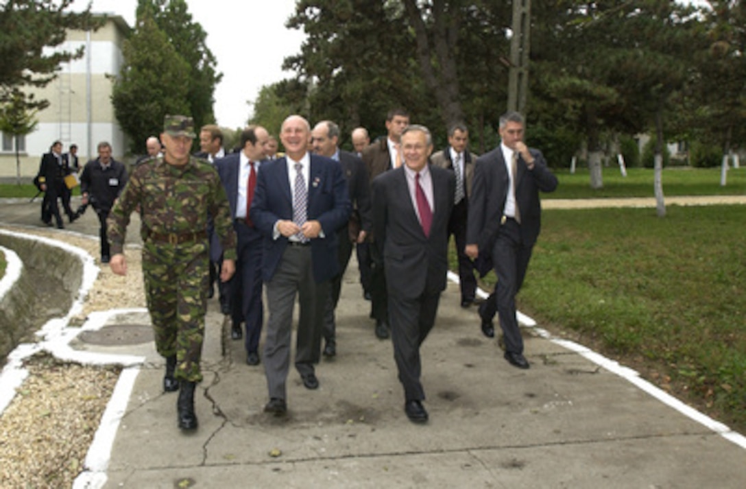 Romanian Minister of Defense Ioan Mircea Pascu (center) escorts Secretary of Defense Donald H. Rumsfeld (front right) and military officials on a tour of Mihail Kogalniceanu Air Base in Constanta, Romania, on Oct 11, 2004. 