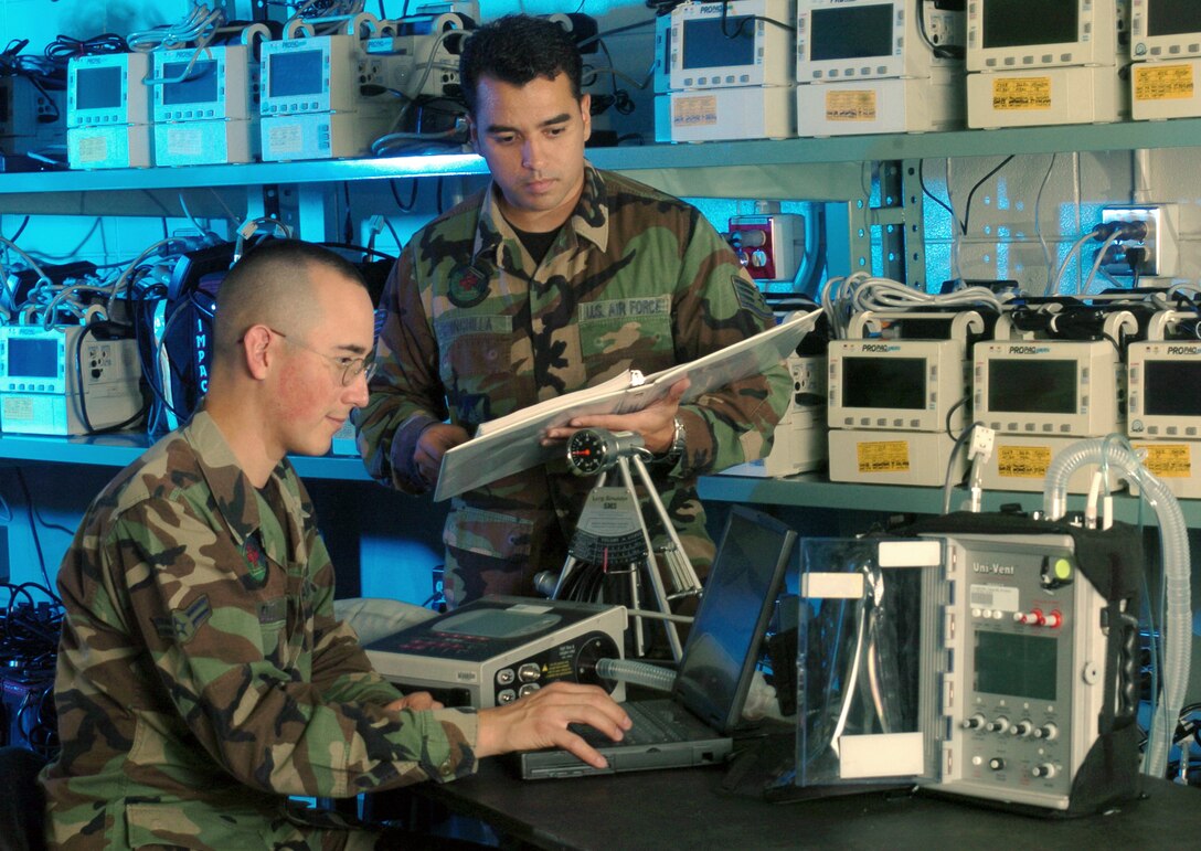YOKOTA AIR BASE, Japan -- Staff Sgt. Sergio Chinchilla (standing) and Airman 1st Class Thomas Elliott calibrate a ventilator during an inspection at the 374th Medical Support Squadron's medical equipment repair center element here.  Both Airmen are biomedical equipment technicians.  The element staff is responsible for acquiring, installing, maintaining and disposing of medical equipment for the base's 374th Medical Group.  They also provide intermediate equipment maintenance for various bases throughout the Pacific region.  (U.S. Air Force photo by Master Sgt. Val Gempis)