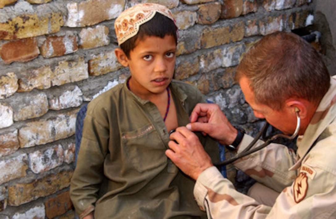 Director of Medical Services for Task Force Victory Lt. Col. Stephen Jones examines the chest of a young Afghan boy during a Cooperative Medical Assistance operation conducted by U.S. Army medical and veterinary personnel in Deh Afghana, Afghanistan, on Sept. 27, 2004. The medical and veterinary personnel are soldiers assigned to Task Force Victory while deployed to Afghanistan in support of Operation Enduring Freedom. 