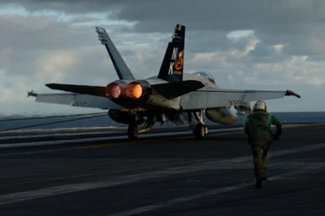 A U.S. Navy aviation boatswain's mate called a tailhook runner rushes toward an F/A-18C Hornet after a successful arrested landing during flight operations aboard the aircraft carrier USS John C. Stennis (CVN 74) on Sept. 26, 2004. The tailhook runner's responsibility is to signal that the tailhook is clear of the arresting wire following the landing. Stennis and its embarked Carrier Air Wing 14 are deployed in the western Pacific Ocean. The F/A-18 is attached to Strike Fighter Squadron 113. 
