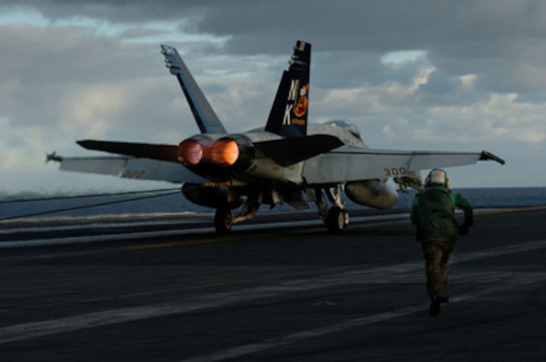 A U.S. Navy aviation boatswain's mate called a tailhook runner rushes ...