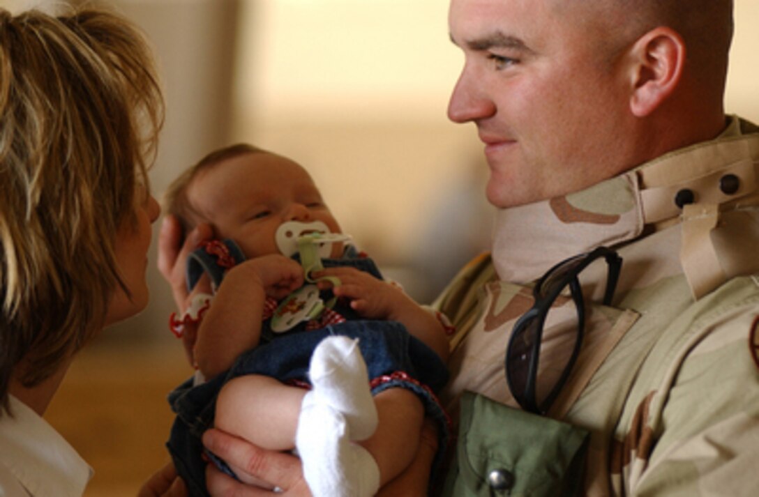 National Guard Staff Sgt. Joel Dalton cradles his seven-week old daughter Camden before boarding a plane to deploy to Iraq from Pope Air Force Base, N.C., on Oct. 6, 2004. Dalton serves with the 105th Military Police Battalion, North Carolina National Guard. 