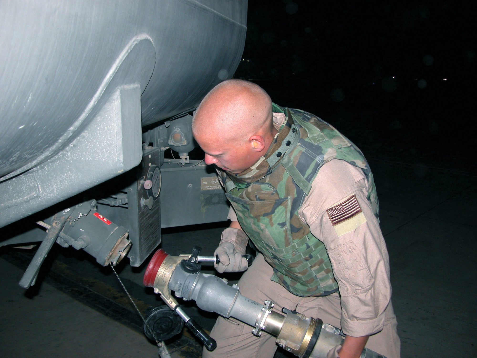 SOUTHWEST ASIA -- Senior Airman Pete Kaplan connects a 3-inch hose to a fuel truck before unloading nearly 3,000 gallons of fuel at a forward-deployed location.  He is part of a four-person team that flies missions with the aerial bulk fuel delivery system.  The system turns cargo aircraft into mobile gas stations, capable of delivering fuel to any location in the area of responsibility.  Airman Kaplan is from Elmendorf Air Force Base, Alaska.  (U.S. Air Force photo by Staff Sgt. Bryan Bouchard)