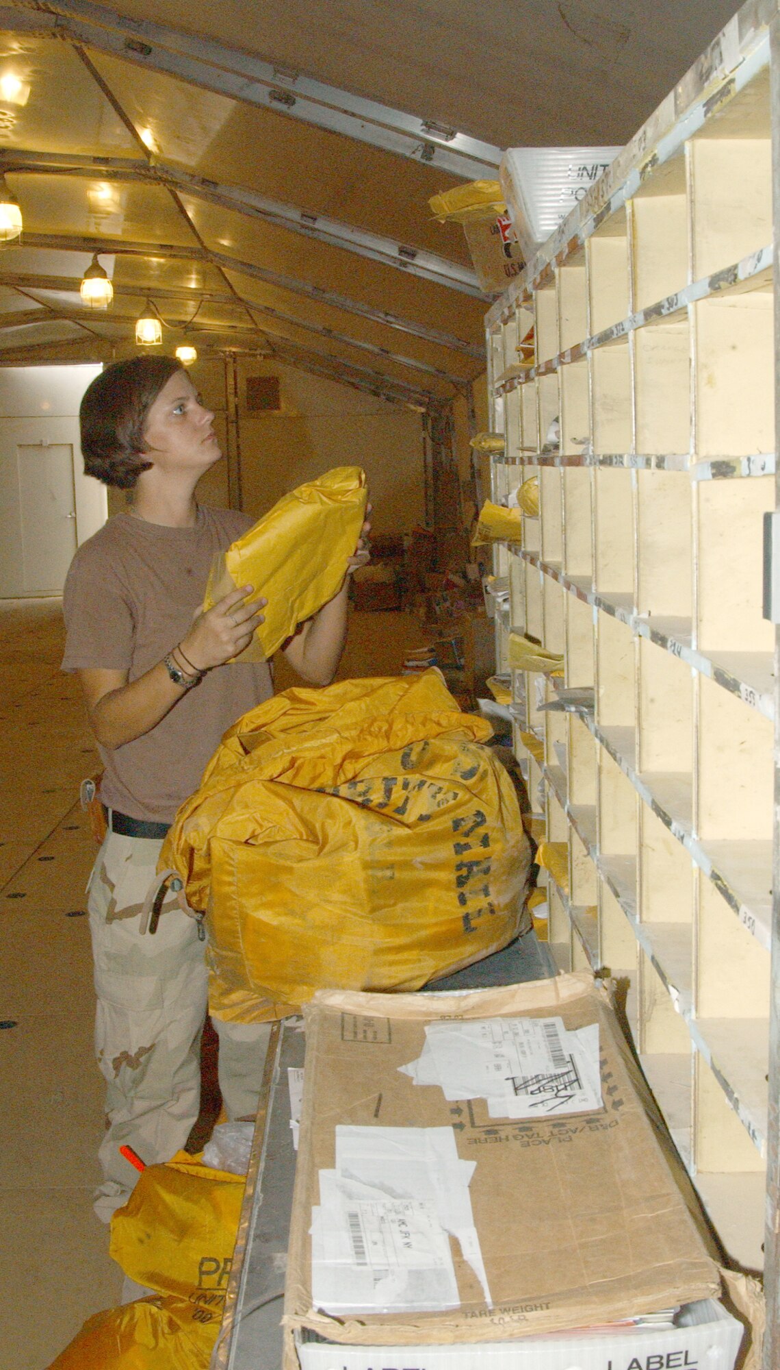 BALAD AIR BASE, Iraq -- Airman 1st Class Kristi Knudson divides mail at the postal facility.  She is one of three full-time postal employees here.  Airman Knudson is a postal augmentee with the 332nd Expeditionary Communications Squadron and is from Eglin Air Force Base, Fla.  (U.S. Air Force photo by Staff Sgt. Ryan Hansen)