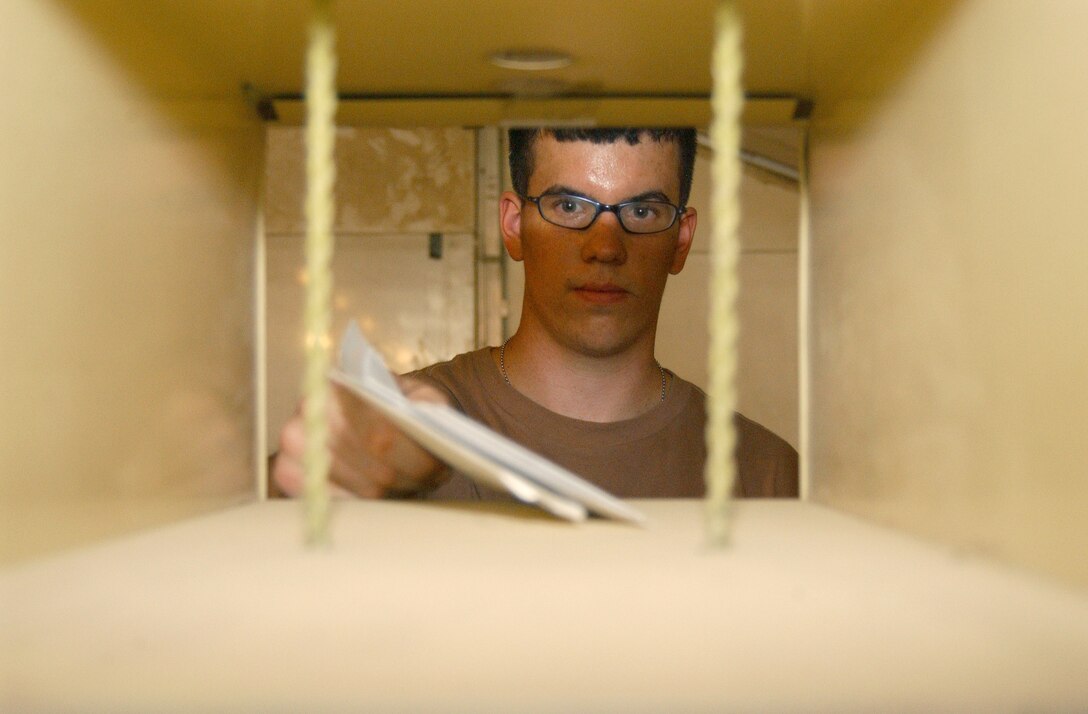 BALAD AIR BASE, Iraq -- Airman Ryan Goldberg puts mail away at the postal facility.  He is one of three full-time postal employees here.  Airman Goldberg is a postal augmentee with the 332nd Expeditionary Communications Squadron and is from Eglin Air Force Base, Fla.  (U.S. Air Force photo by Staff Sgt. Ryan Hansen)