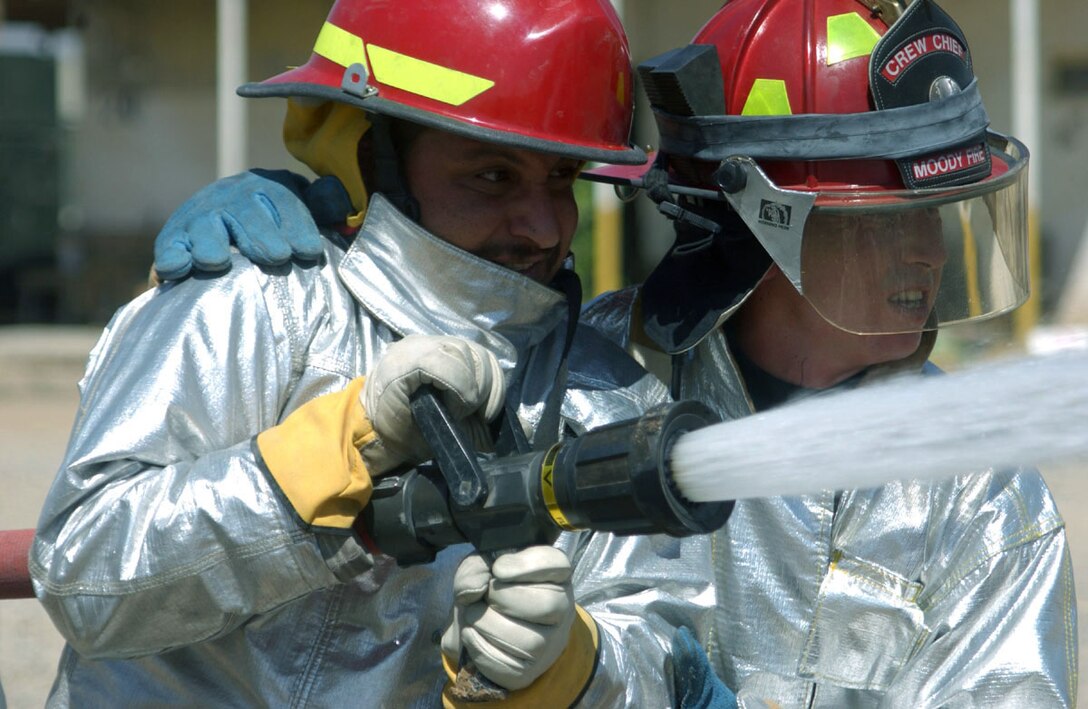 KIRKUK AIR BASE, Iraq -- Staff Sgt. Shannon Anderson shows an Iraqi firefighter how to attack a fire during a joint training session here.  Sergeant Anderson is assigned to the 506th Expeditionary Civil Engineer Squadron's fire department and is from Moody Air Force Base, Ga.  (U.S. Air Force photo by Staff Sgt. Adrian Cadiz)