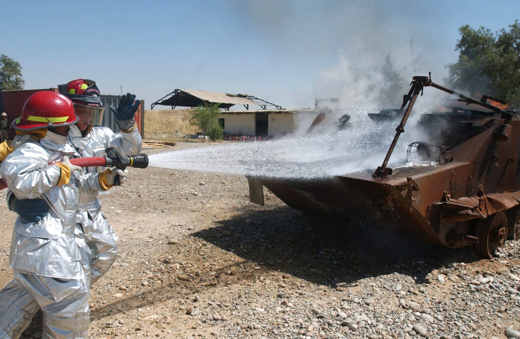 KIRKUK AIR BASE, Iraq -- Staff Sgt. Shannon Anderson shows an Iraqi firefighter how to attack a fire during a joint training session here.  Sergeant Anderson is assigned to the 506th Expeditionary Civil Engineer Squadron's fire department and is from Moody Air Force Base, Ga.  (U.S. Air Force photo by Staff Sgt. Adrian Cadiz)
