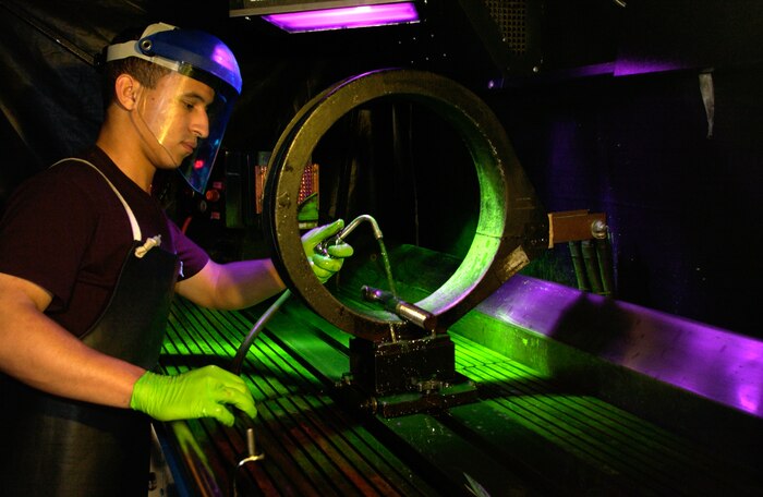 CHARLESTON AIR FORCE BASE, S.C. -- Airman 1st Class Kenny Payamps uses fluorescent magnetic particle testing to inspect a water separator bolt from a C-17 Globemaster here.  Airman Payamps is a non-destructive inspection testing journeyman assigned to the 437th Maintenance Squadron.  (U.S. Air Force photo by Tech. Sgt John M. Foster)