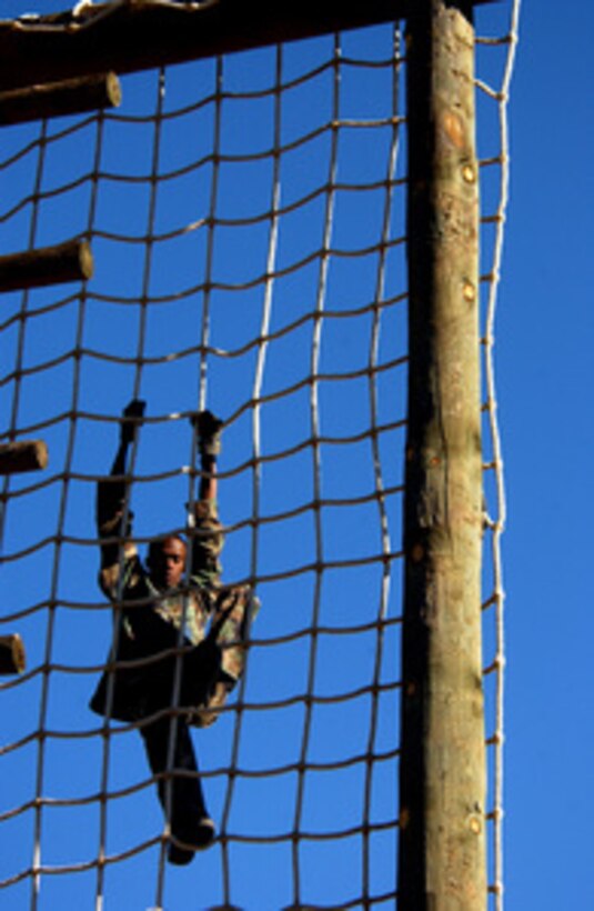 Senior Airman Greg Davidson, U.S. Air Force, climbs the netting on the first training obstacle named "Tough One," at Fort Huachuca, Ariz., on Oct. 14, 2004. Members of U.S. Air Forces in Europe Defender Challenge team are spending three weeks in Sierra Vista, Ariz., preparing for the 2004 Defender Challenge competition being held at Lackland Air Force Base, Texas. Defender Challenge is a security forces competition pitting teams from major commands against one another over a series of events including marksmanship, tactics and physical fitness. Davidson is assigned to the 48th Security Forces Squadron, Lakenheath Air Base, United Kingdom. 