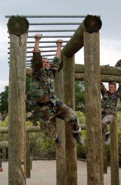 FORT HUACHUCA, Ariz. -- Senior Airman Dustin McPhillips swings hand to hand on the training obstacle named "Tarzan" here Oct. 18.  Members of the U.S. Air Forces in Europe Defender Challenge team are spending three weeks here in preparation for the 2004 Defender Challenge competition. The security forces competition is held at Lackland Air Force Base, Texas.  Airman McPhillips is assigned to the 568th Security Forces Squadron at Ramstein Air Base, Germany.  (U.S. Air Force photo by Tech. Sgt. Justin D. Pyle)