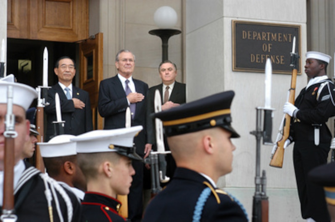 Honor guard members salute as Secretary of Defense Donald H. Rumsfeld (center top of stairs) and South Korean Minister of National Defense Yoon Kwang-ung (left) stand at attention for the playing of the national anthems of both nations during welcoming ceremonies at the Pentagon on Oct. 22, 2004. Their meetings will mark the start of the 36th annual U.S.-Republic of Korea Security Consultative Meeting. Deputy Assistant Secretary of Defense for Asian and Pacific Affairs Richard Lawless (right) will join the defense leaders in the talks. A broad range of bilateral security issues are on the table for discussion. 