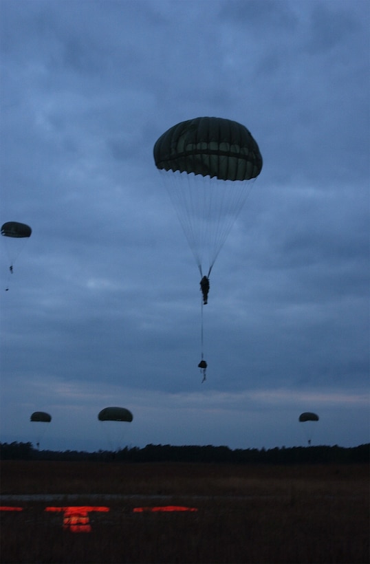 MARINE CORPS BASE CAMP DAVIS, N.C. - A Marine C-130J drops a contingent, or stick, of airborne Marines across the twilight evening sky over drop zone Pheasant recently.  The Marines, assigned to 2d Air Delivery Platoon, 2nd Transportation Support Battalion, II Force Service Support Group, and a smattering of other Marines from various other units concluded a successful week of airborne and air delivery operations with a night airborne jump.