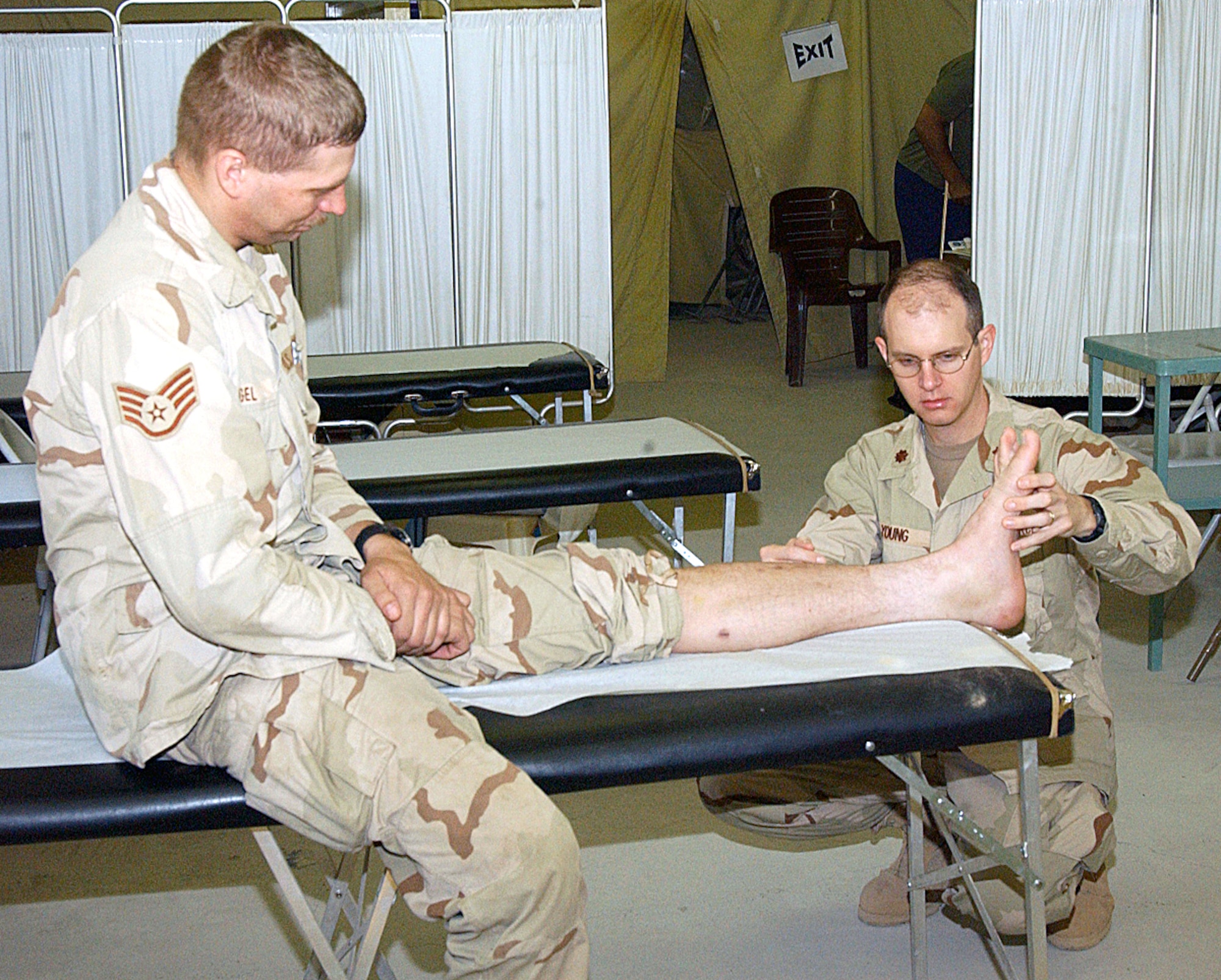 BALAD AIR BASE, Iraq -- Maj. Brian Young looks at Staff Sgt. Eric Vogel's ankle.  Major Young is a physical therapist with the 332nd Expeditionary Medical Group here, and Sergeant Vogel is assigned to the 732nd Expeditionary Logistics Readiness Squadron.  (U.S. Air Force photo by Staff Sgt. Ryan Hansen)