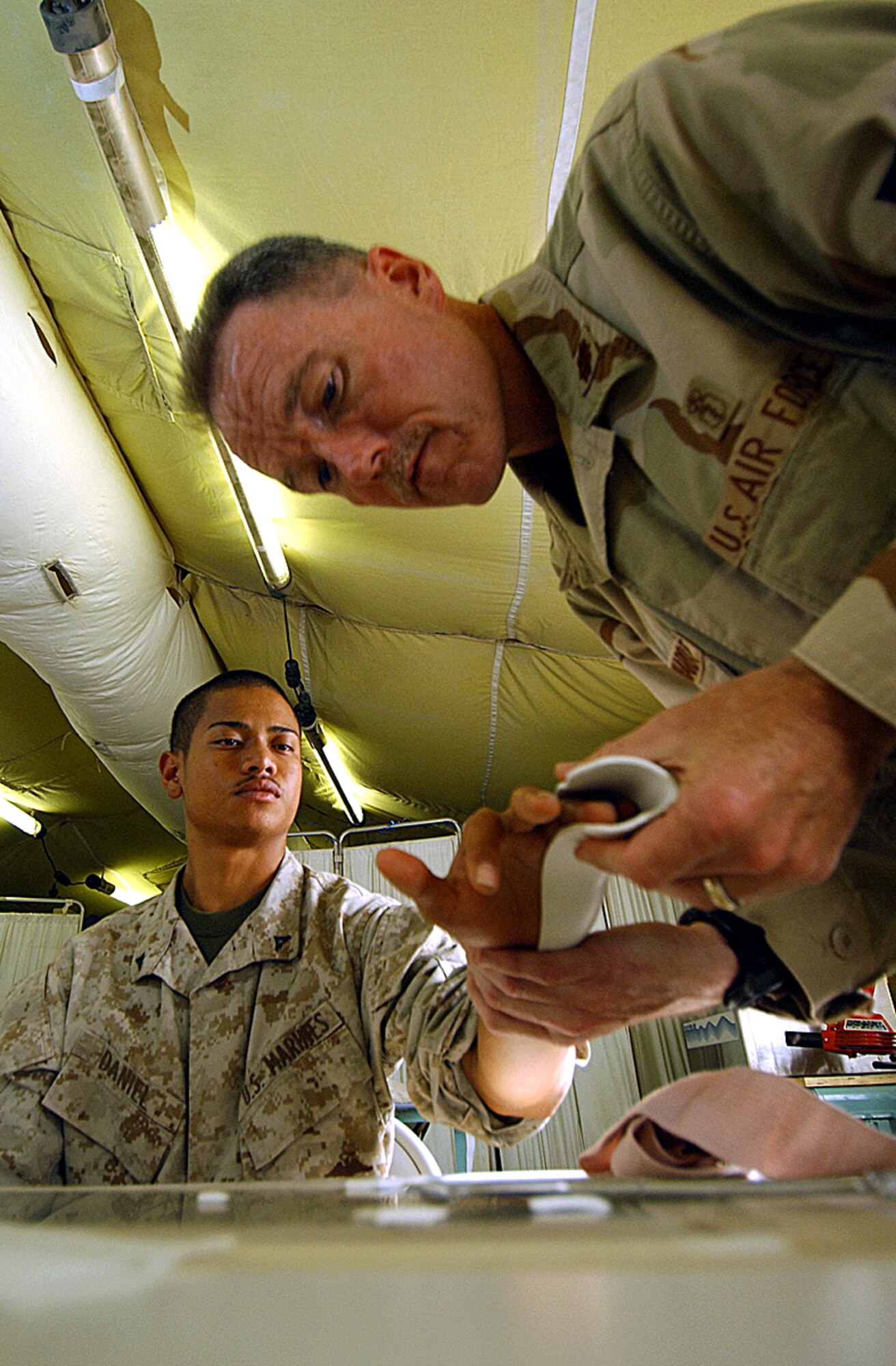 BALAD AIR BASE, Iraq -- Maj. Peter Reinhardt fits a splint for Marine Lance Cpl. Kai Daniel, who was visiting the Air Force theater hospital here from Tikrit.  Major Reinhardt is an occupational therapist with the 332nd Expeditionary Medical Group here.  (U.S. Air Force photo by Tech. Sgt. Robert Jensen)